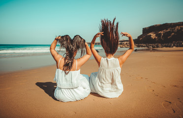 Chicas vestidas de blanco disfrutando en un bonito paisaje de la playa