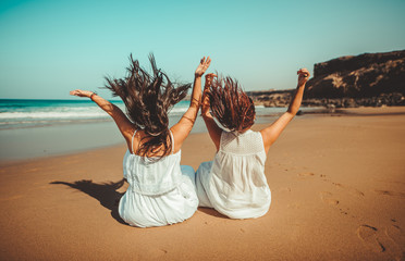 Chicas vestidas de blanco disfrutando en un bonito paisaje de la playa