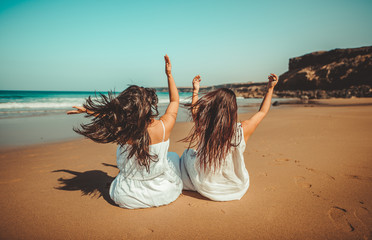 Chicas vestidas de blanco disfrutando en un bonito paisaje de la playa