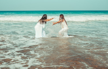 Chicas vestidas de blanco disfrutando en un bonito paisaje de la playa