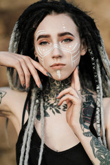 Beautiful sexy woman in black underwear. The body is covered with many tattoos. Dreadlocks on the...