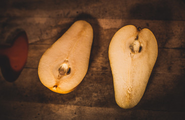 Pera en un fondo de madera  y rodeada por granos de café