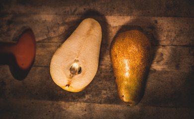 Pera en un fondo de madera  y rodeada por granos de café