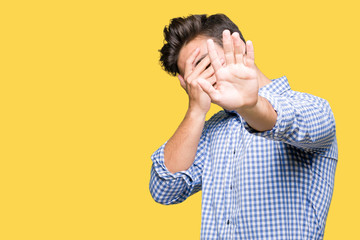 Young handsome business man over isolated background covering eyes with hands and doing stop gesture with sad and fear expression. Embarrassed and negative concept.