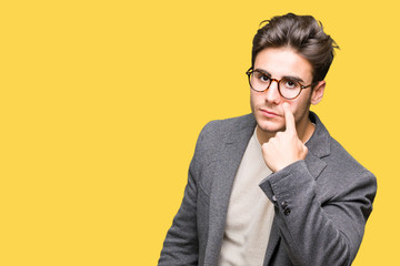 Young business man wearing glasses over isolated background Pointing to the eye watching you gesture, suspicious expression