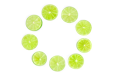Vibrant fresh lime slices, shot from above on a white background forming a circular frame for copy space