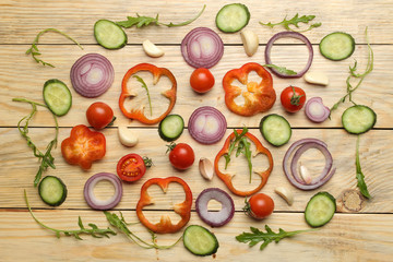 Ingredients for cooking salad. background from Various vegetables and spices carrot, tomato, onion, cucumber, pepper and arugula on a natural wooden table. top view.