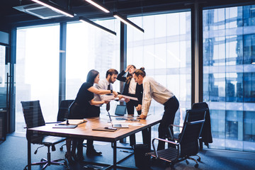 Tired female director in office feeling headache during deadline with employees cooperating on accounting near desktop, group of mature men and women checking information from financial reports