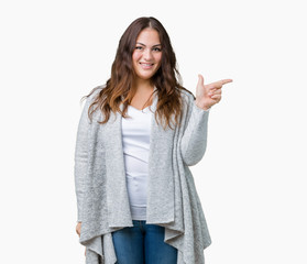 Beautiful plus size young woman wearing winter jacket over isolated background with a big smile on face, pointing with hand and finger to the side looking at the camera.