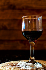 Glass of iced red wine in a rustic setting.