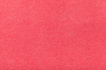 Light red matt suede fabric closeup. Velvet texture of felt.