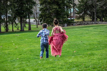 Fototapeta premium BOY & GIRL RUNNING ON GRASSY FIELD