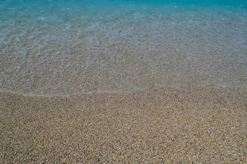 Sea wave on the shore of a pebble beach, water, foam, background