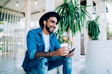 Turkish male blogger resting outdoors with caffeine beverage enjoying spare time for visiting...
