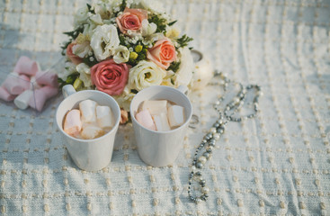 Obraz na płótnie Canvas wedding photography. wedding details winter wedding. two cups with and marshmallows, a bridal bouquet and wedding rings