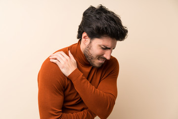 Handsome over isolated wall suffering from pain in shoulder for having made an effort