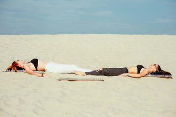 extreme yoga relaxation and self-development - beautiful women laying nacked back on the board with...