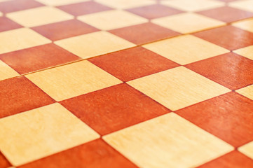 Wooden chess board as abstract background. Close up.