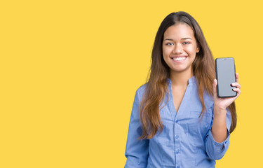 Young beautiful brunette business woman showing screen of smartphone over isolated background with a happy face standing and smiling with a confident smile showing teeth