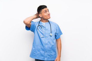 Young surgeon doctor man over isolated white wall having doubts and with confuse face expression