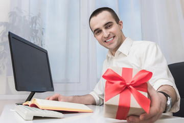 Attractive male gives a gift, young boss is gives a gift
