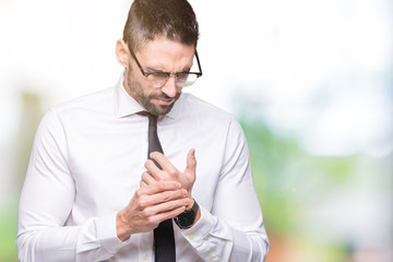 Young handsome business man wearing glasses over isolated background Suffering pain on hands and fingers, arthritis inflammation