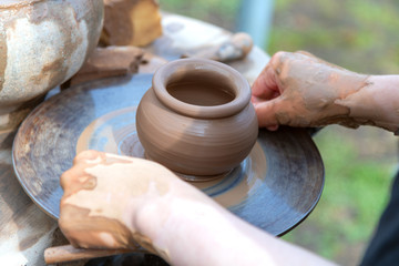 Potter's hands making clay pot.
