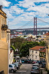 Prazeres, Lisbon, Portugal - June 25, 2019 - Alley in Necessities overlooking the 25 de April Bridge and Tejo River