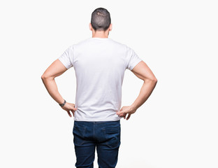 Fototapeta premium Handsome man wearing white t-shirt over white isolated background standing backwards looking away with arms on body
