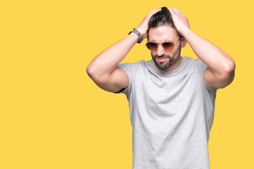 Young handsome man wearing sunglasses over isolated background suffering from headache desperate and stressed because pain and migraine. Hands on head.