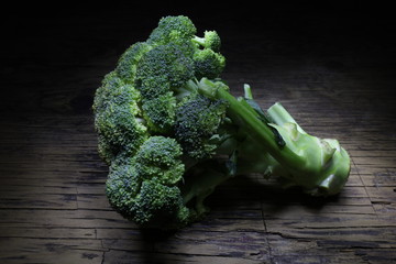 BROCCOLO IN PRIMO PIANO SU TAGLIERE DI LEGNO IN LIGHT PAINTING