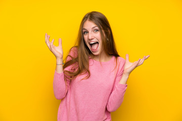 Young woman with long hair over isolated yellow wall smiling a lot