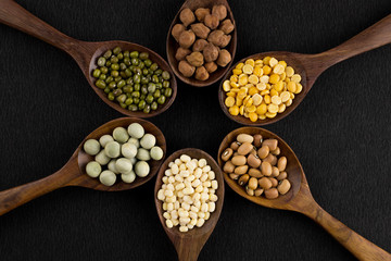 collection set of urad dal, beans, green peas, lentils, rice in wooden spoons.