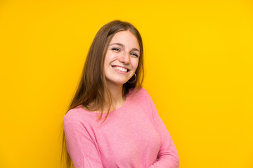 Fototapeta premium Young woman with long hair over isolated yellow wall smiling