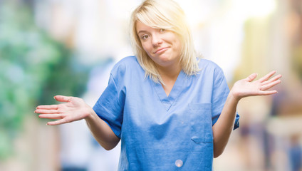 Young beautiful blonde nurse doctor woman over isolated background clueless and confused expression...