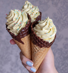 Three ice cream cones in female hand