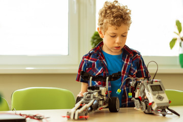 Serious curly boy looking at the vehicle models