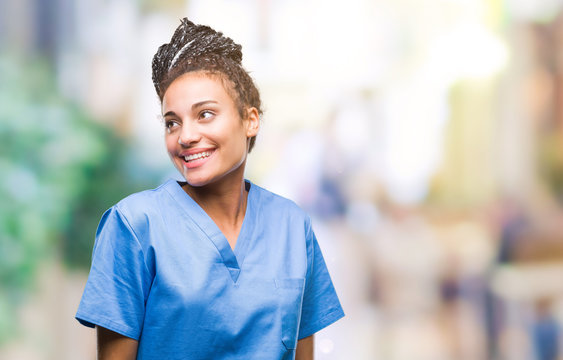 Young Braided Hair African American Girl Professional Nurse Over Isolated Background Looking Away To Side With Smile On Face, Natural Expression. Laughing Confident.