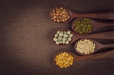 collection set of urad dal, beans, green peas, lentils, rice in wooden spoons.
