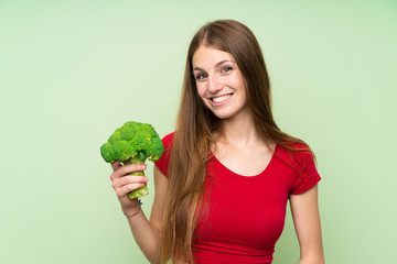 Young woman with long hair holding a broccoli