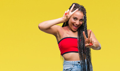 Young braided hair african american with pigmentation blemish birth mark over isolated background smiling looking to the camera showing fingers doing victory sign. Number two.