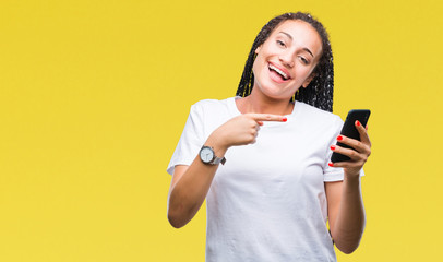 Naklejka premium Young braided hair african american girl showing using smartphone over isolated background very happy pointing with hand and finger