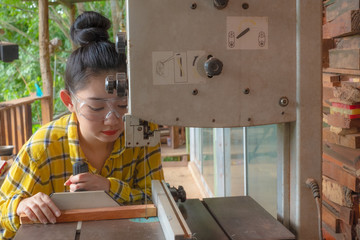Women standing is craft working cut wood at a work bench