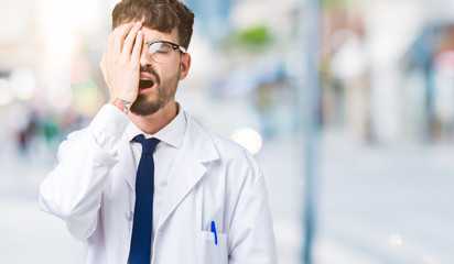 Young professional scientist man wearing white coat over isolated background Yawning tired covering half face, eye and mouth with hand. Face hurts in pain.