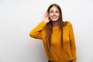 Young woman with yellow over isolated white wall listening something