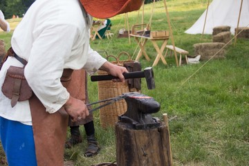 Blacksmithing. Hammer and anvil. Blacksmith forging iron. Medieval reconstruction