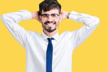 Young handsome business man wearing glasses over isolated background Relaxing and stretching with arms and hands behind head and neck, smiling happy
