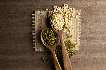 collection set of urad dal, beans, green peas, lentils, rice in wooden spoons.