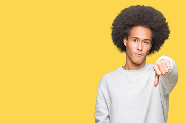 Fototapeta na wymiar Young african american man with afro hair wearing sporty sweatshirt looking unhappy and angry showing rejection and negative with thumbs down gesture. Bad expression.