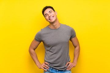 Handsome man over isolated yellow wall smiling